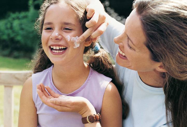 Mother applying sunscreen to child